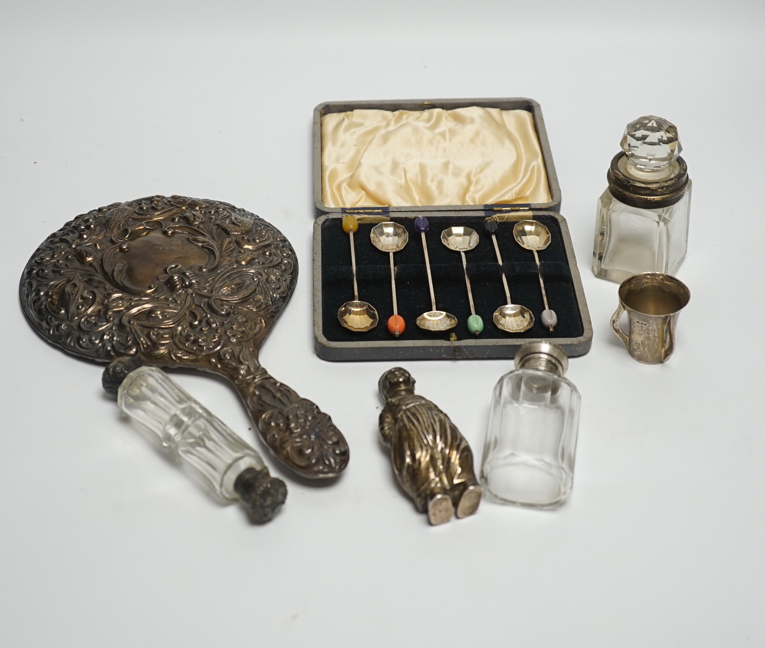 A Hanau silver novelty figural pepperette and other small silver including a silver mounted hand mirror, scent bottles and a small tyg and a cased set of plated spoons.